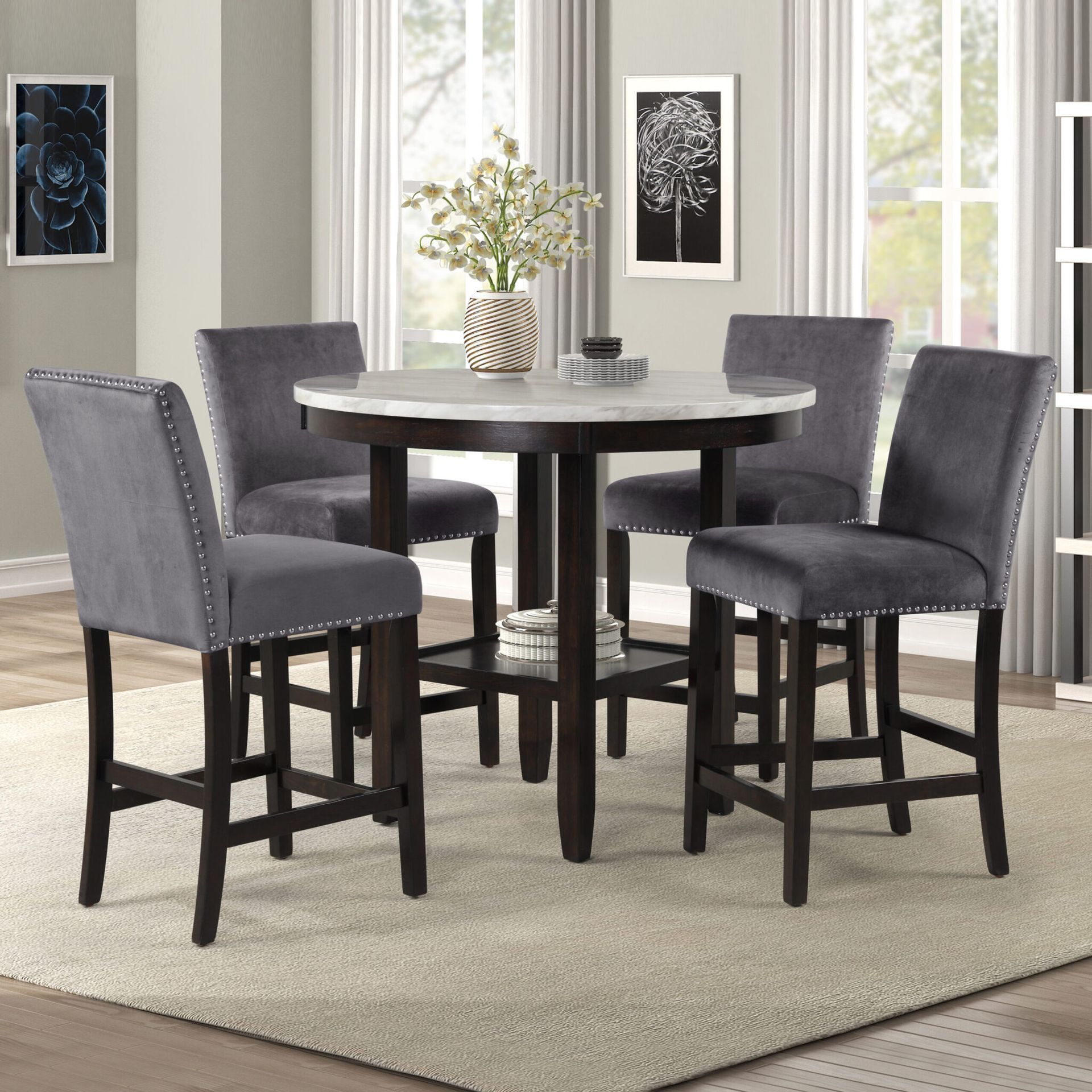 Round dining table with four gray upholstered chairs in a bright living room