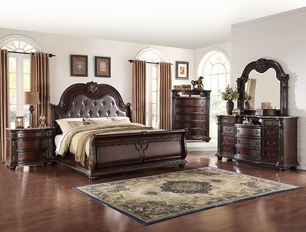 Elegant dark wood bedroom set with bed, dressers, mirrors, and a patterned rug on a hardwood floor