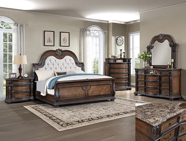 Elegant traditional bedroom with carved dark wood furniture, cream bedding, and a patterned rug