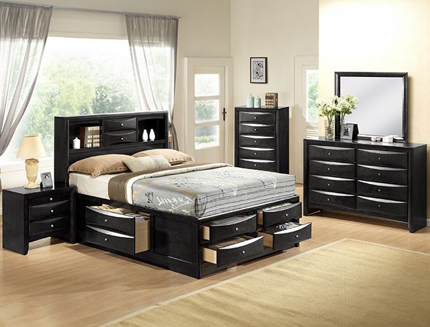 Modern black bedroom set with storage bed, dresser, nightstands, and a mirror in a bright room