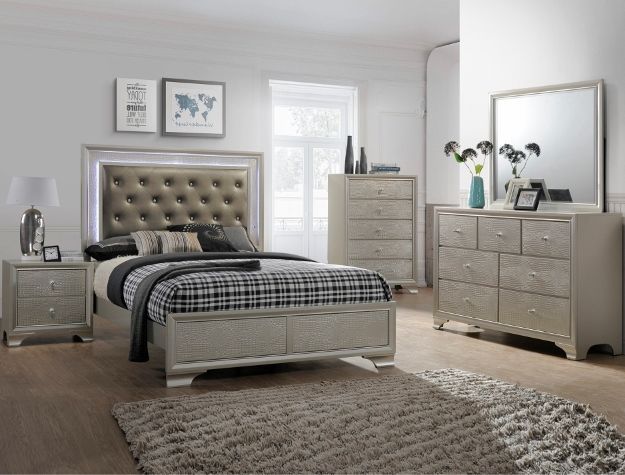 Gray tufted bedroom set with bed, dresser, nightstand, mirror, and shag rug in a bright room