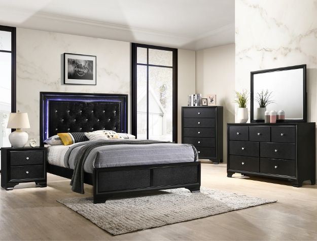 Modern bedroom with black furniture, blue tufted headboard, and light wood flooring