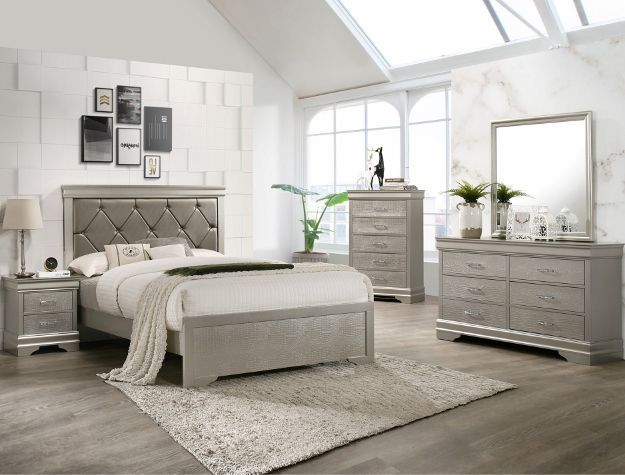 Modern light-gray bedroom with tufted bed, dresser, mirror, and rug in a bright windowed room