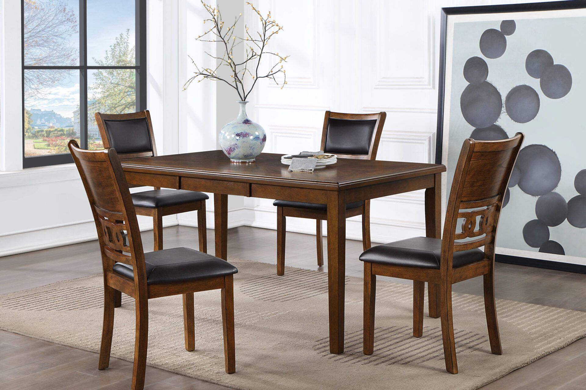 Wooden dining table with four chairs in a bright modern room with large windows and wall art