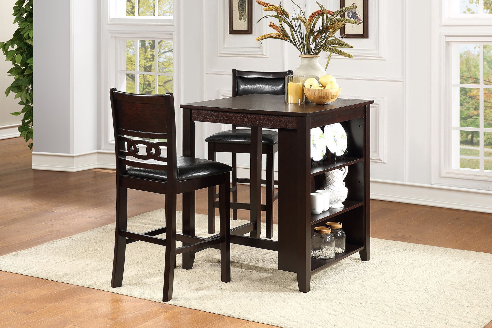 Dark wood pub table set with two chairs in a bright dining room beside tall windows