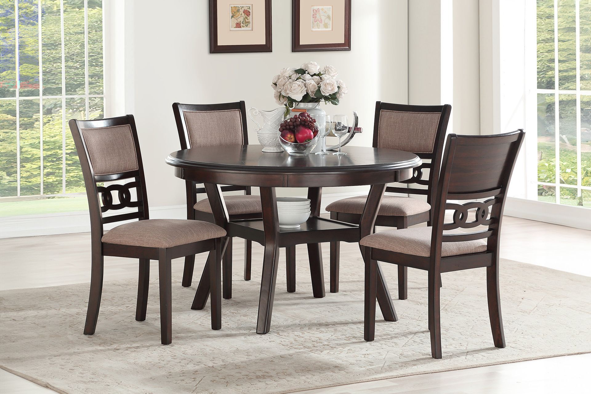 Dark wood dining table and four chairs in a bright room with a floral centerpiece and framed wall art.