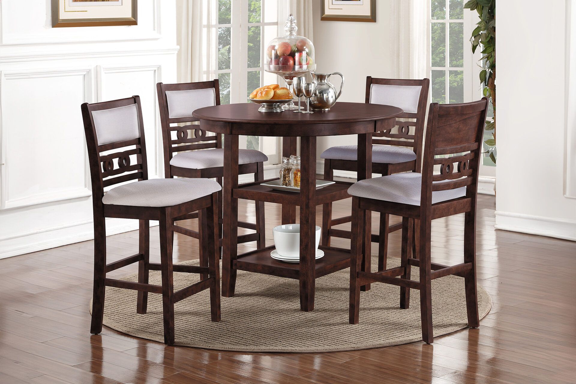 Round wooden dining table with four chairs and a centerpiece in a bright room