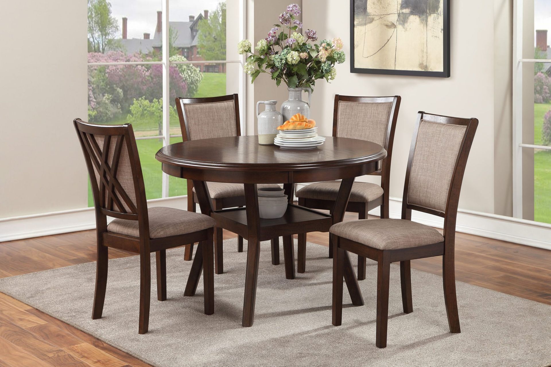 Dark wood dining table with four chairs in a bright dining room beside windows.