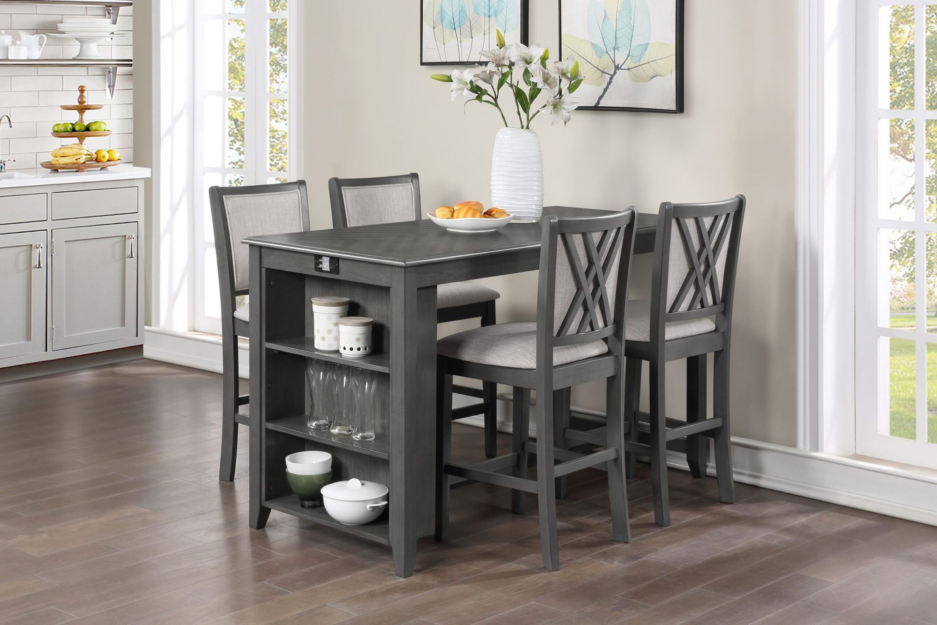 Black dining table with four chairs in a bright kitchen nook, with shelving and decor nearby