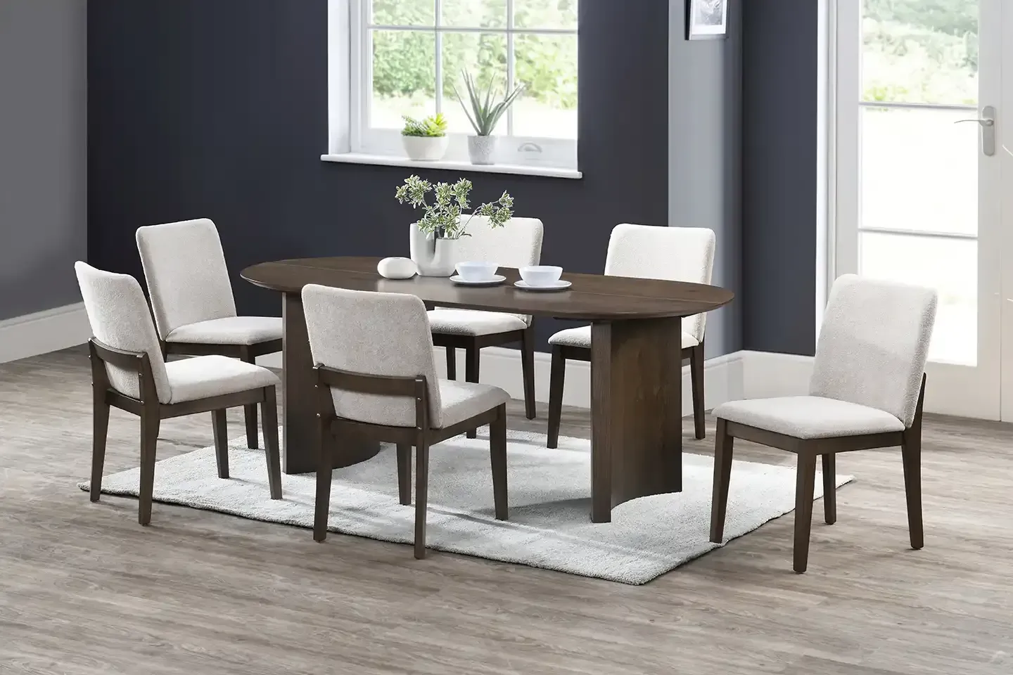 Modern dining set with wooden table and upholstered chairs in a bright gray room
