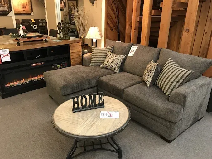 Cozy living room with gray sectional sofa, round coffee table, and electric fireplace
