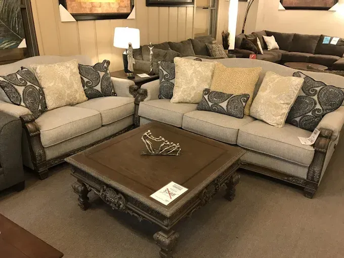 Living room with two beige sofas, a dark wood coffee table, and warm table lamps