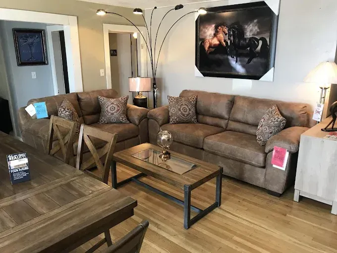 Living room with brown sectional sofa, coffee table, floor lamp, and wall art