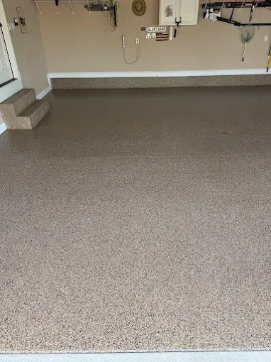 Garage floor with a speckled, light brown epoxy coating.