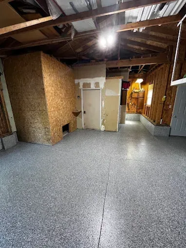 Interior of a garage with a speckled gray epoxy floor.