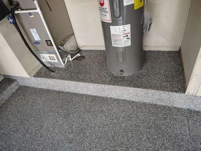 Garage floor with speckled gray epoxy coating, water heater, and heating unit.