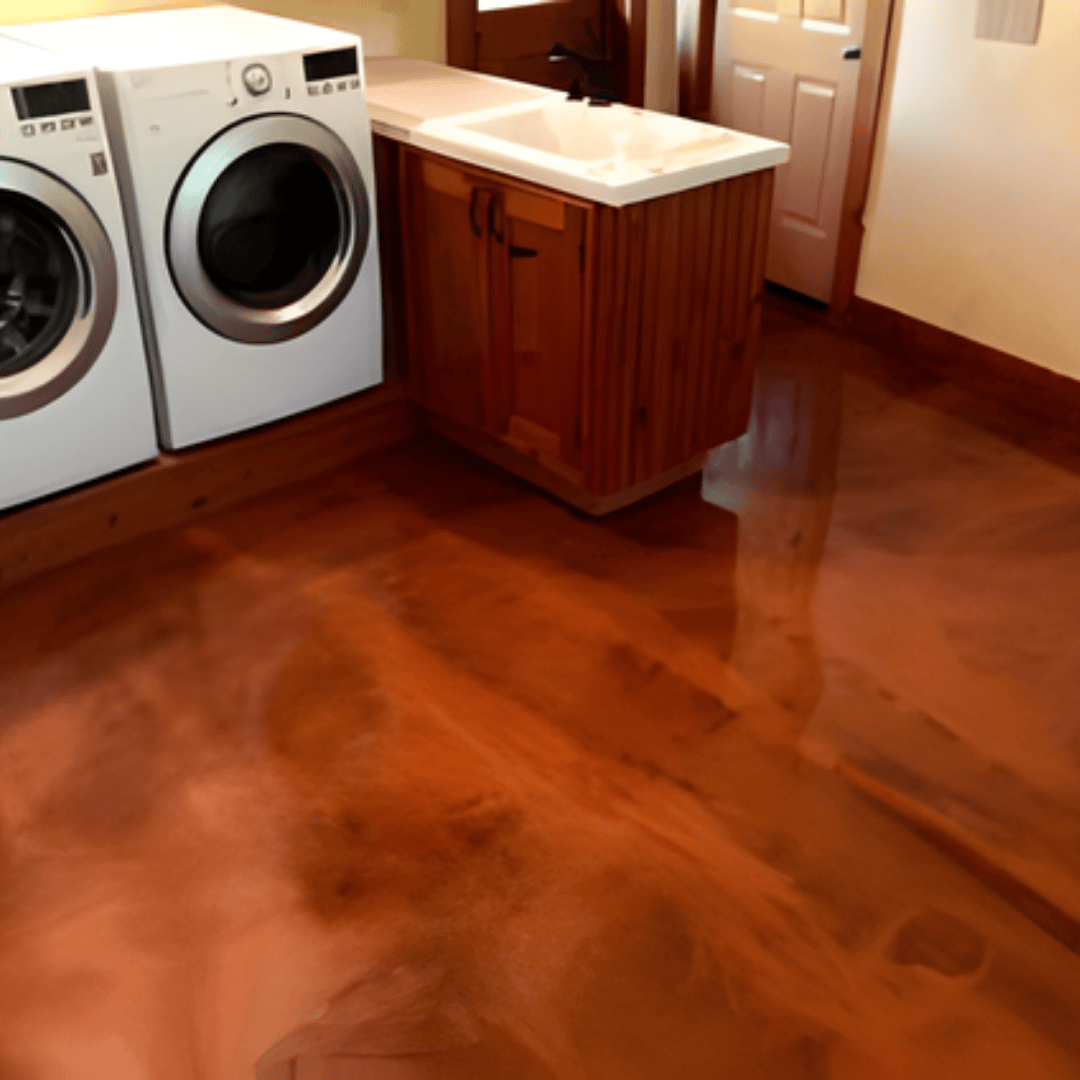 Laundry room with a metallic copper-colored epoxy floor, washer, dryer, sink, and cabinets.