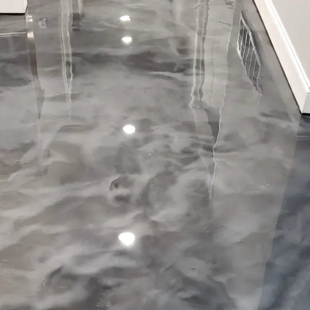 Metallic gray epoxy floor with swirling patterns reflecting overhead lights.