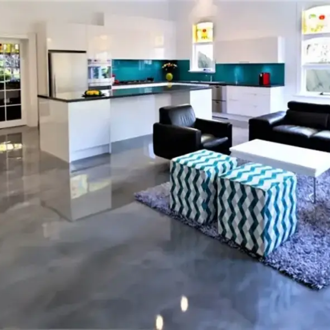 Modern kitchen and living space with glossy grey floor, white cabinets, and teal backsplash.