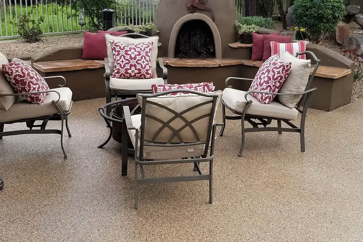 Patio seating area with fire pit, built-in benches, and red patterned cushions.