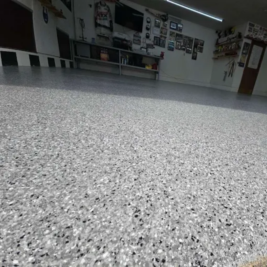Grey epoxy floor with black and white flakes in a garage.