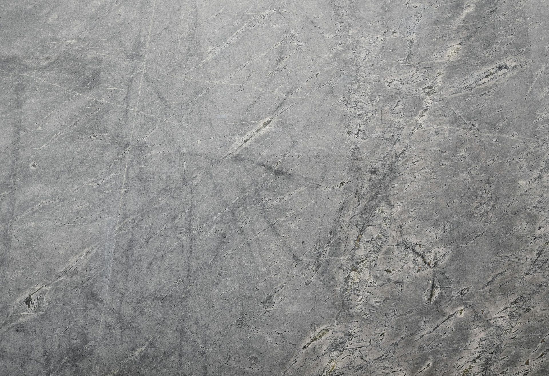 Gray concrete surface with minor surface imperfections and scratches.