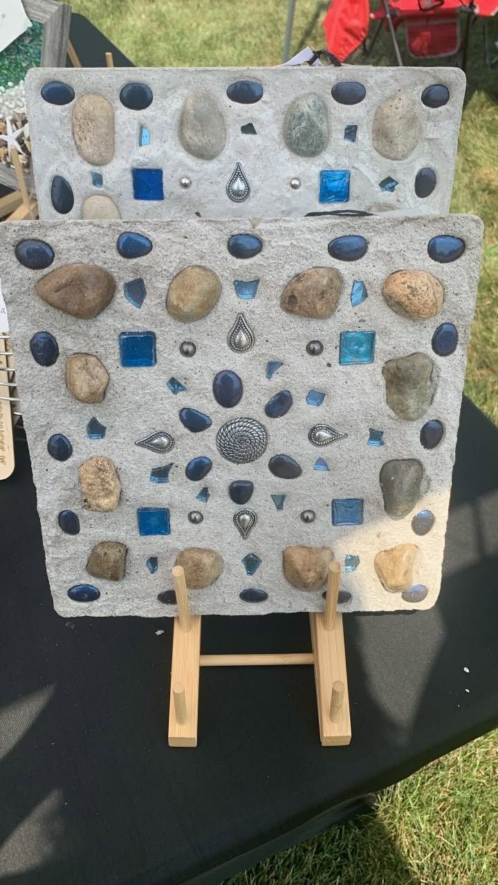 Small rock-climbing wall with multicolored holds on wooden supports outdoors on grass