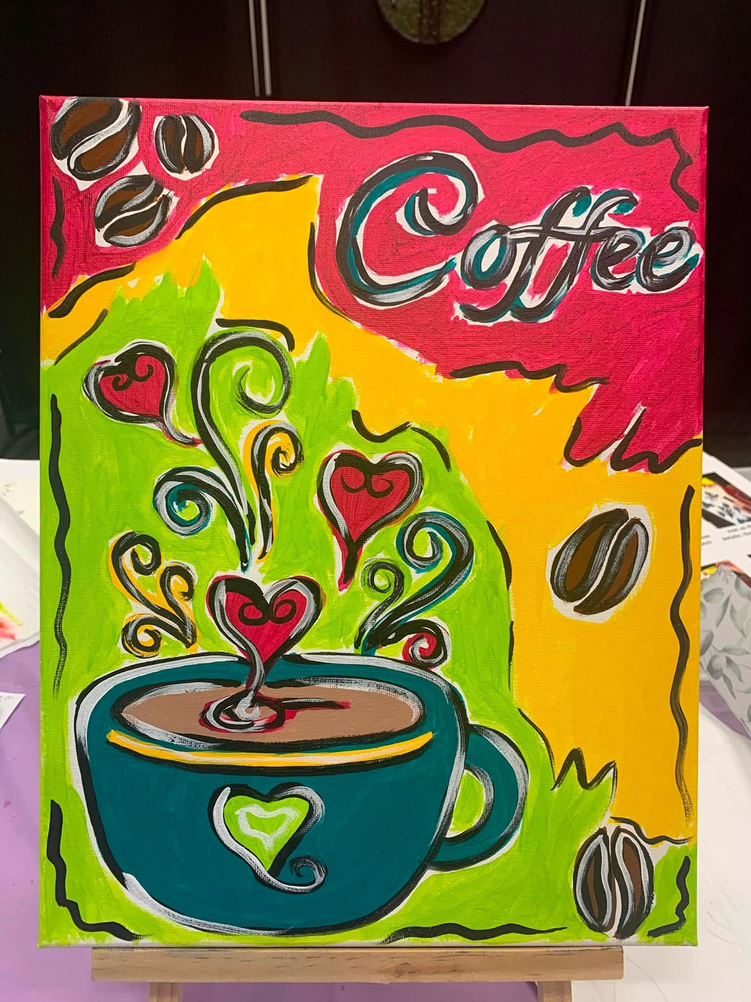 Colorful painting of a steaming coffee cup with hearts and the word “Coffee” on a bright background