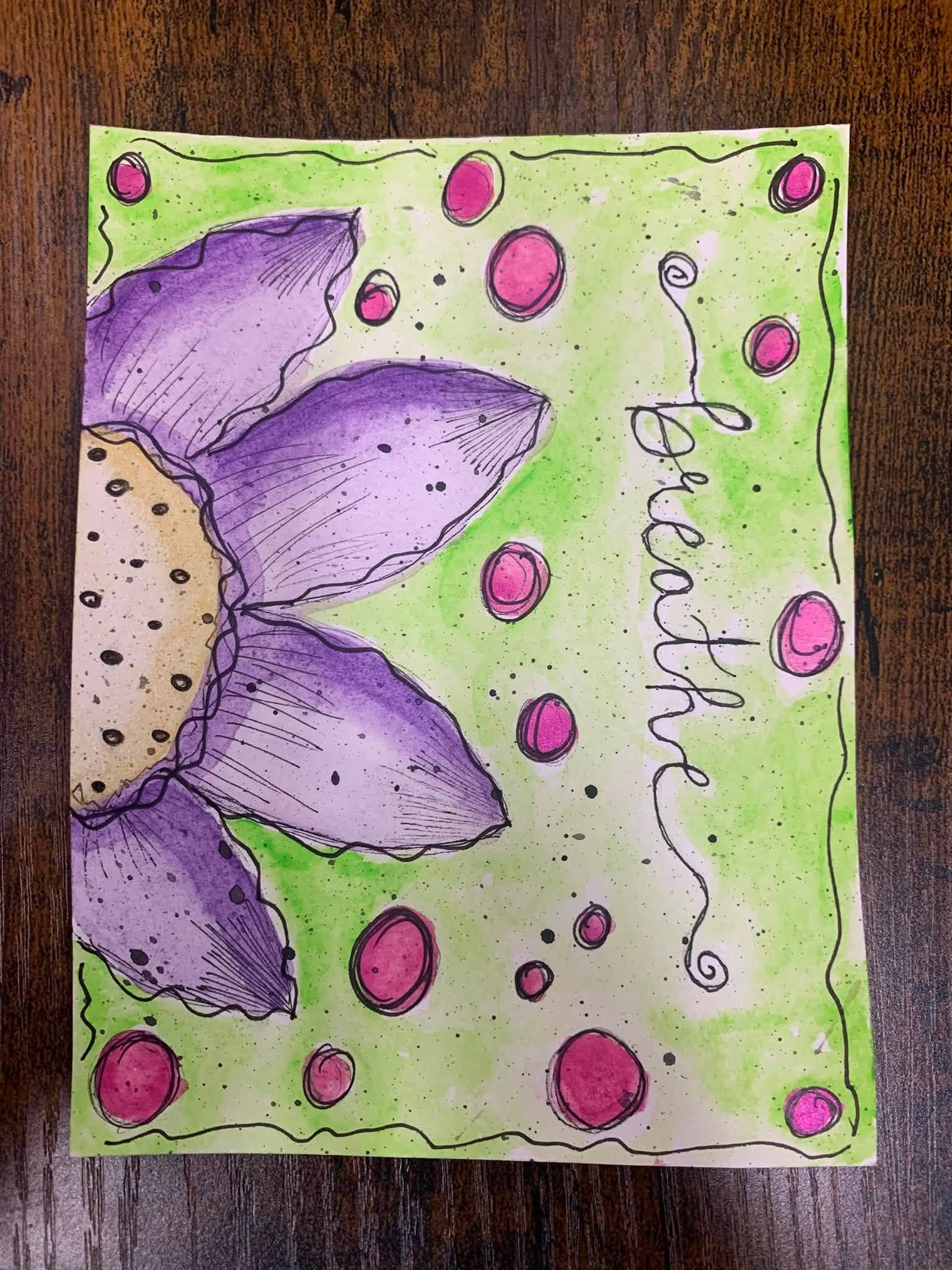 Purple flower drawing on green background with pink dots and the word 