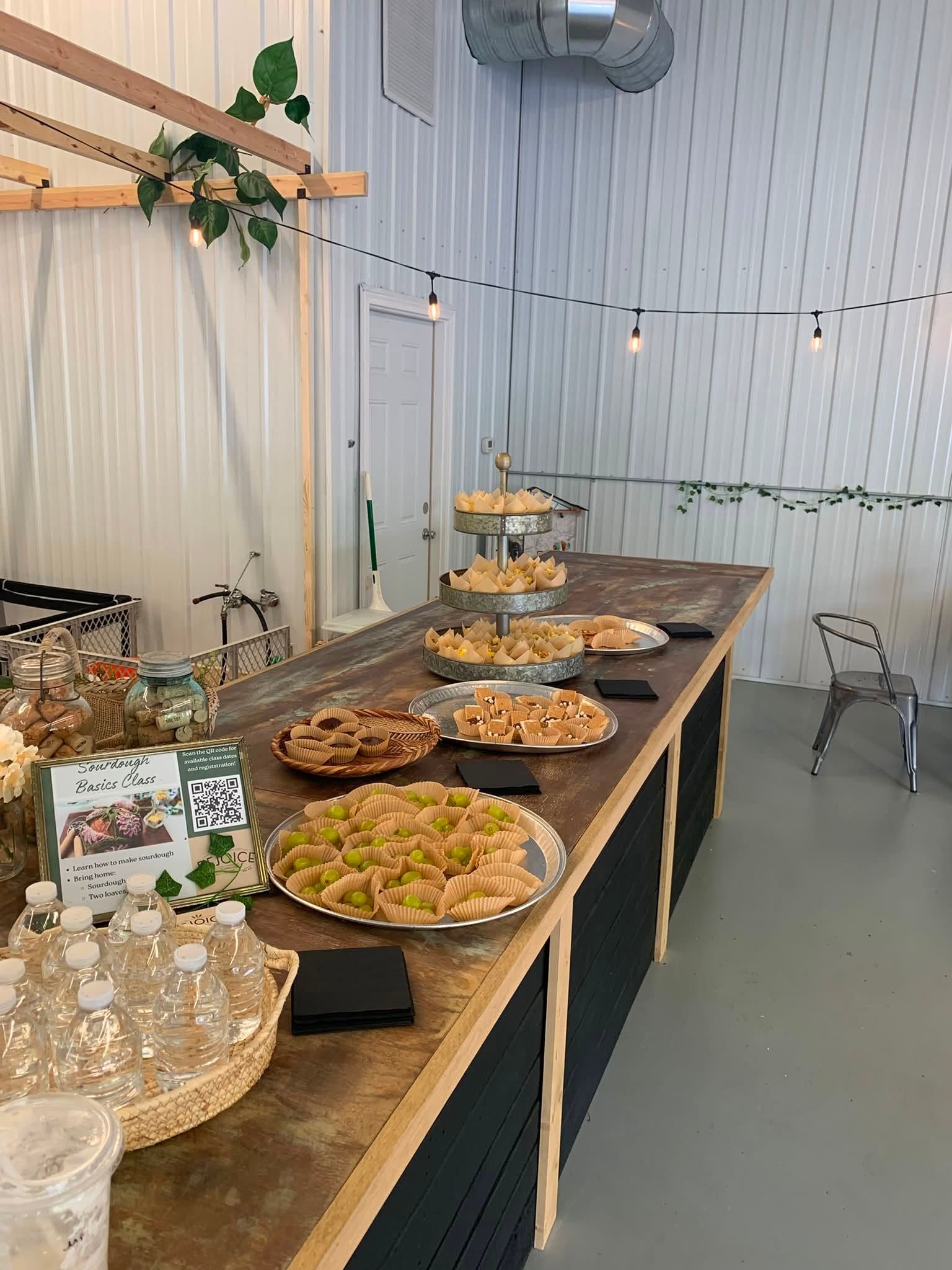 Dessert buffet on wooden tables with plates of pastries, cakes, and cookies in a white tented event space