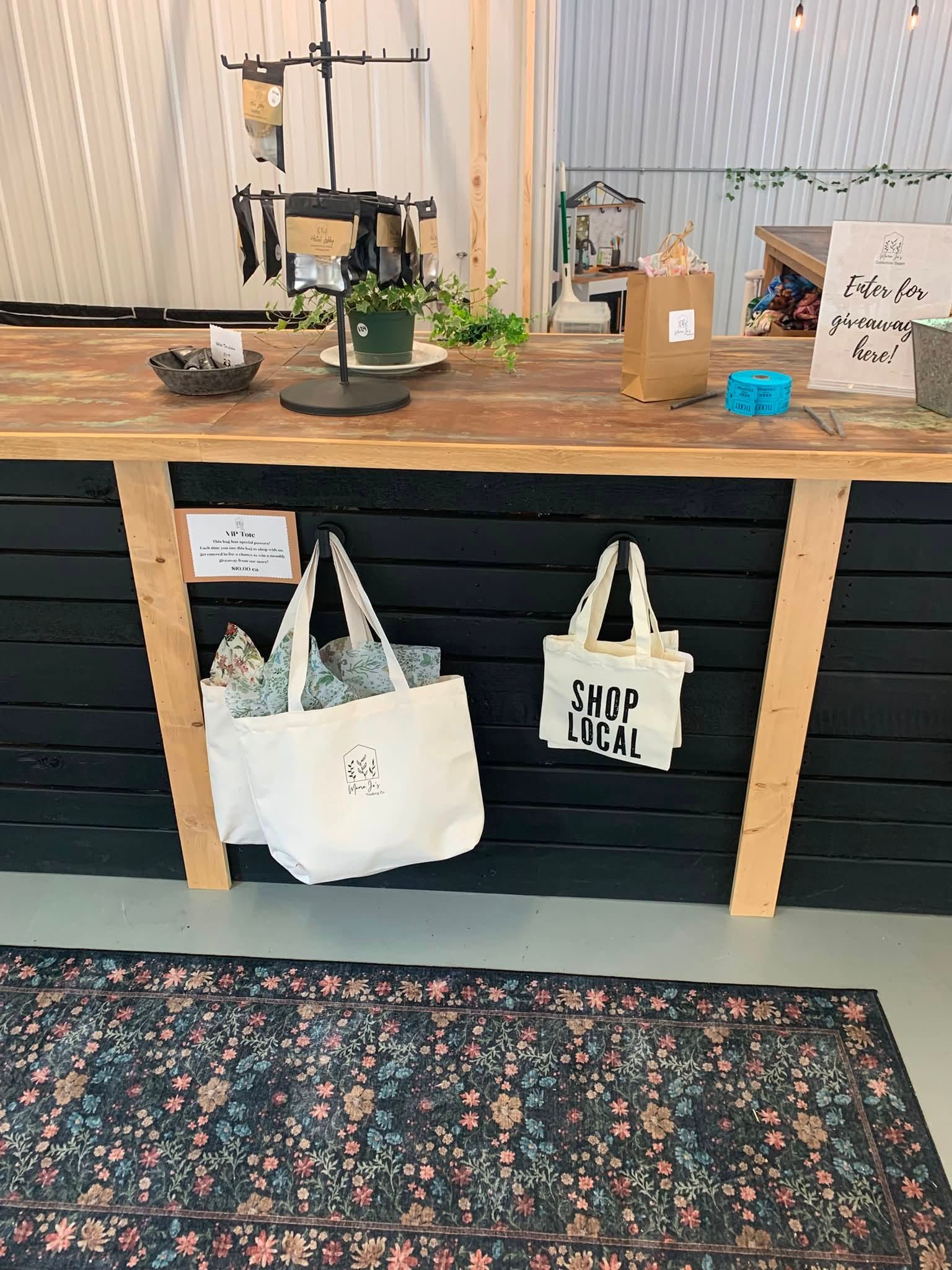 Wooden counter with hanging tote bags, plants, and decor in a cozy shop or café interior.