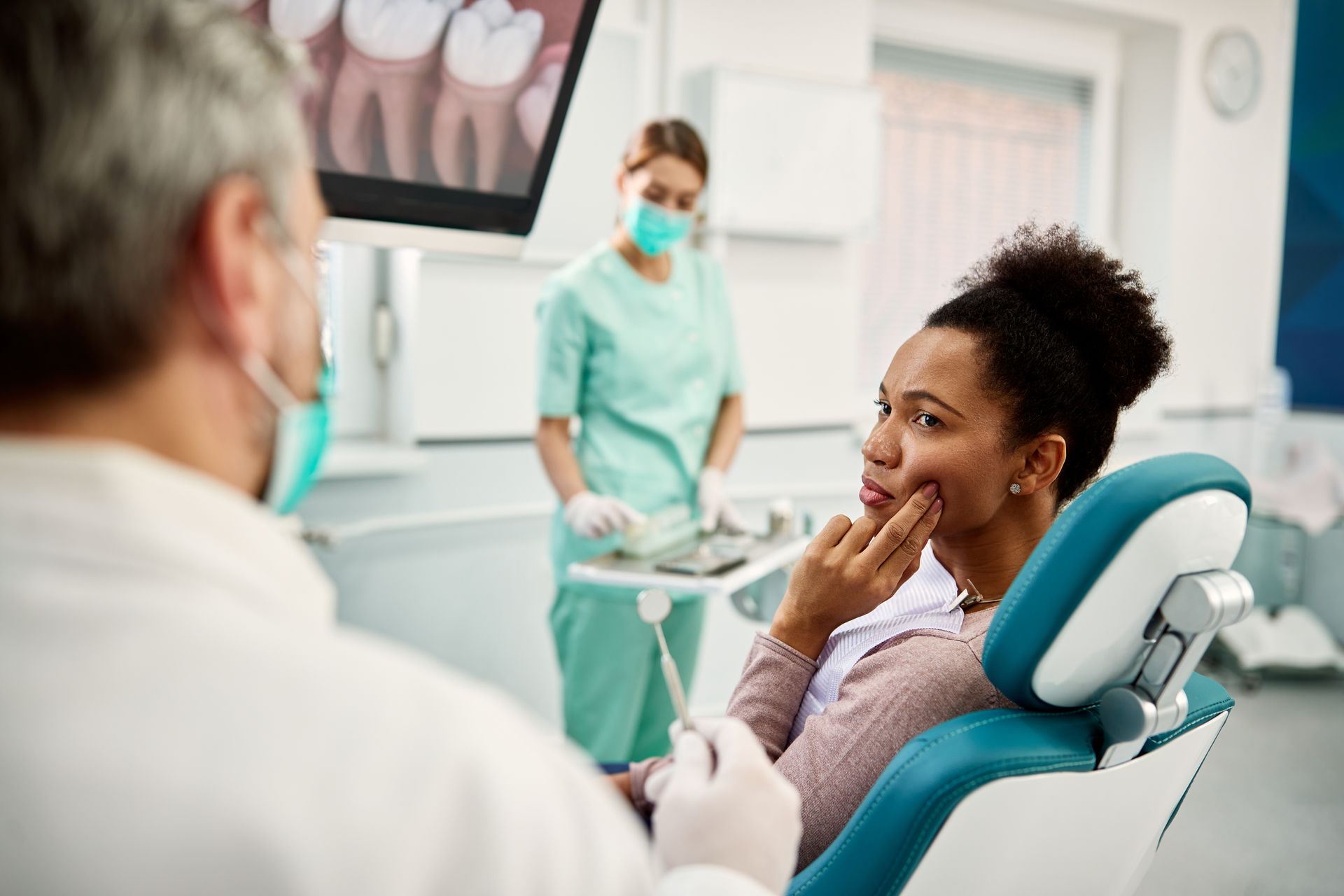 A woman is at a dental office with a toothache.
