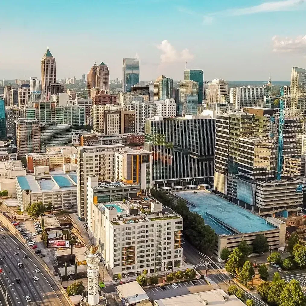 Aerial view of a modern city skyline with high-rise buildings and a busy roadway.