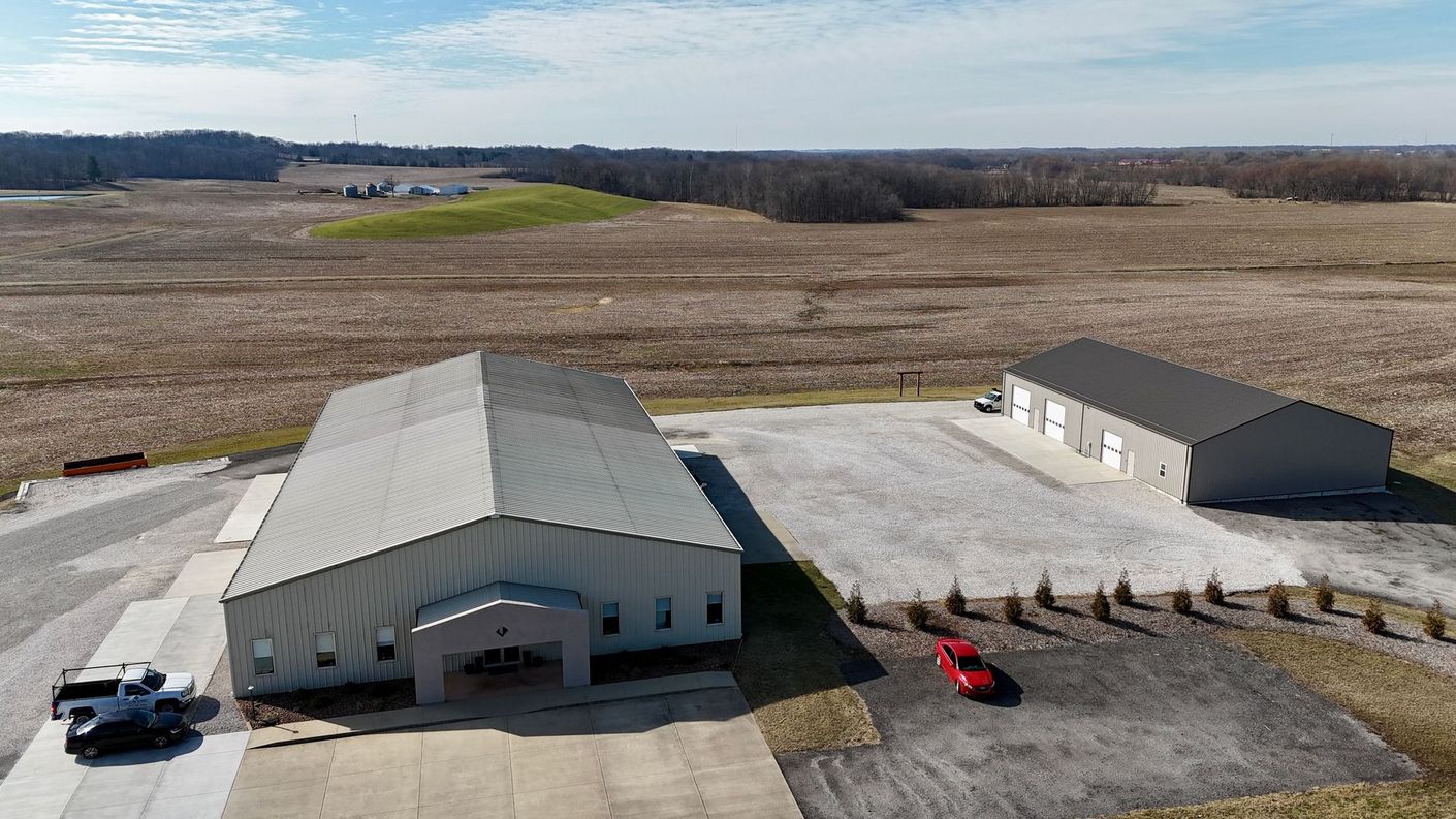 An aerial view of a large building in the middle of a field.