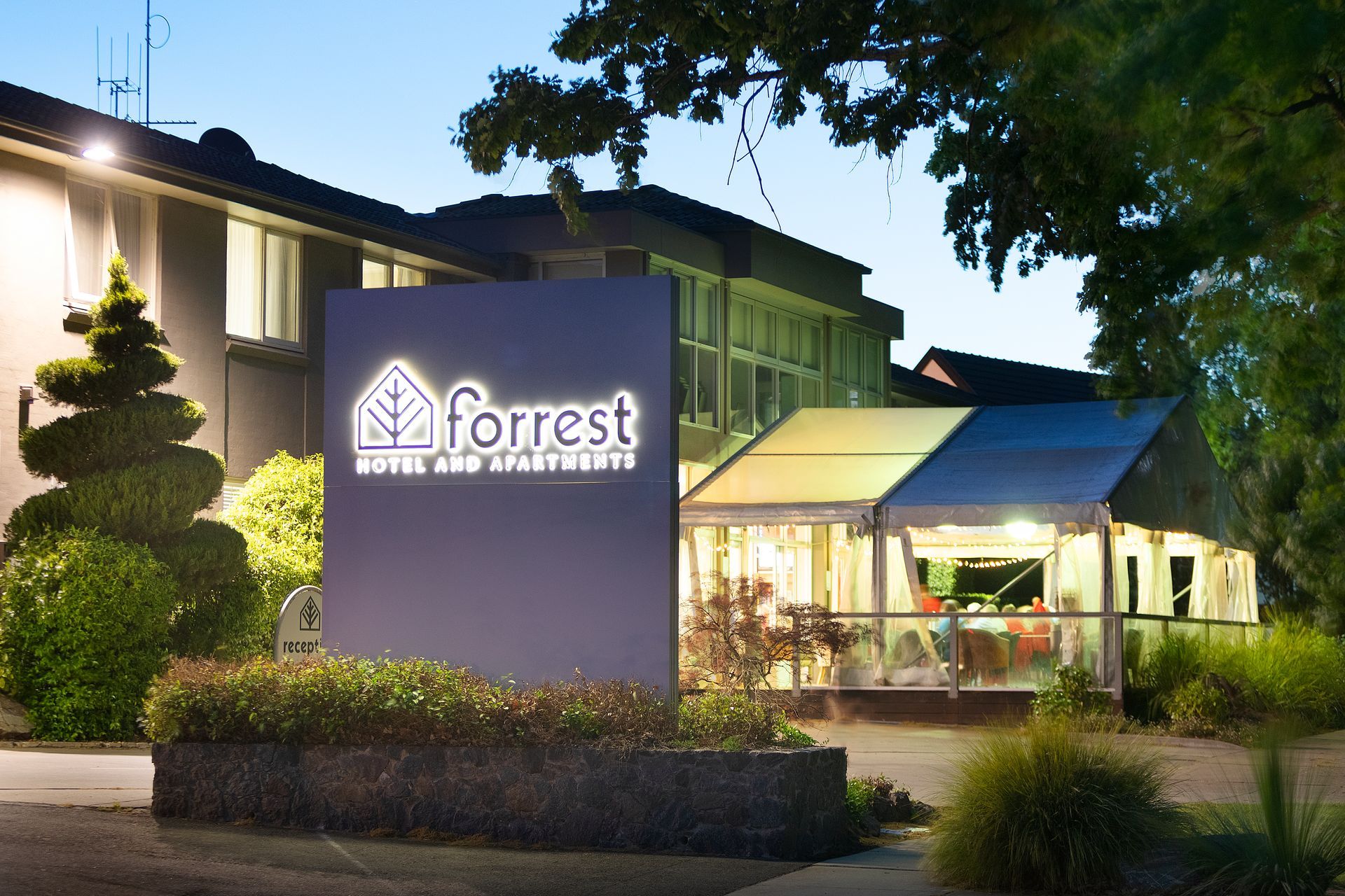 Forrest Dental Centre building at dusk with illuminated sign and entrance surrounded by landscaping