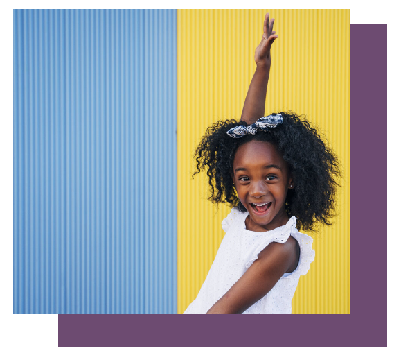 A little girl in a white dress is raising her hand in the air.