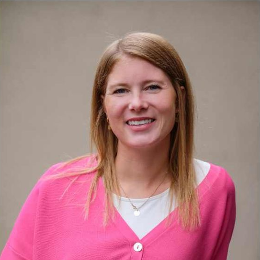 Bild von Ann Kristin Martini, die einen rosa Pullover und ein weißes Hemd trägt, lächelt.