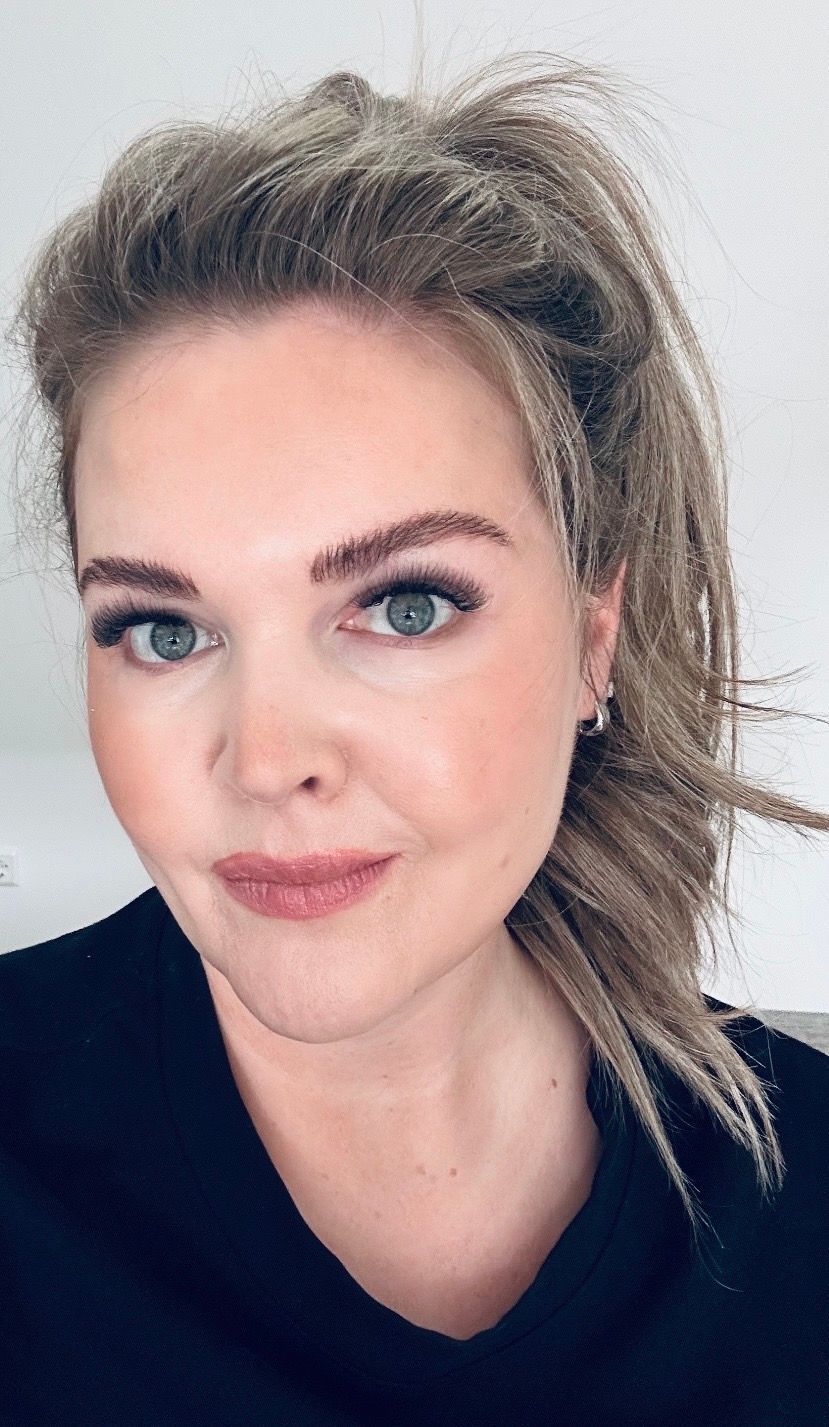 Eine Frau mit langen blonden Haaren trägt ein schwarzes Hemd.