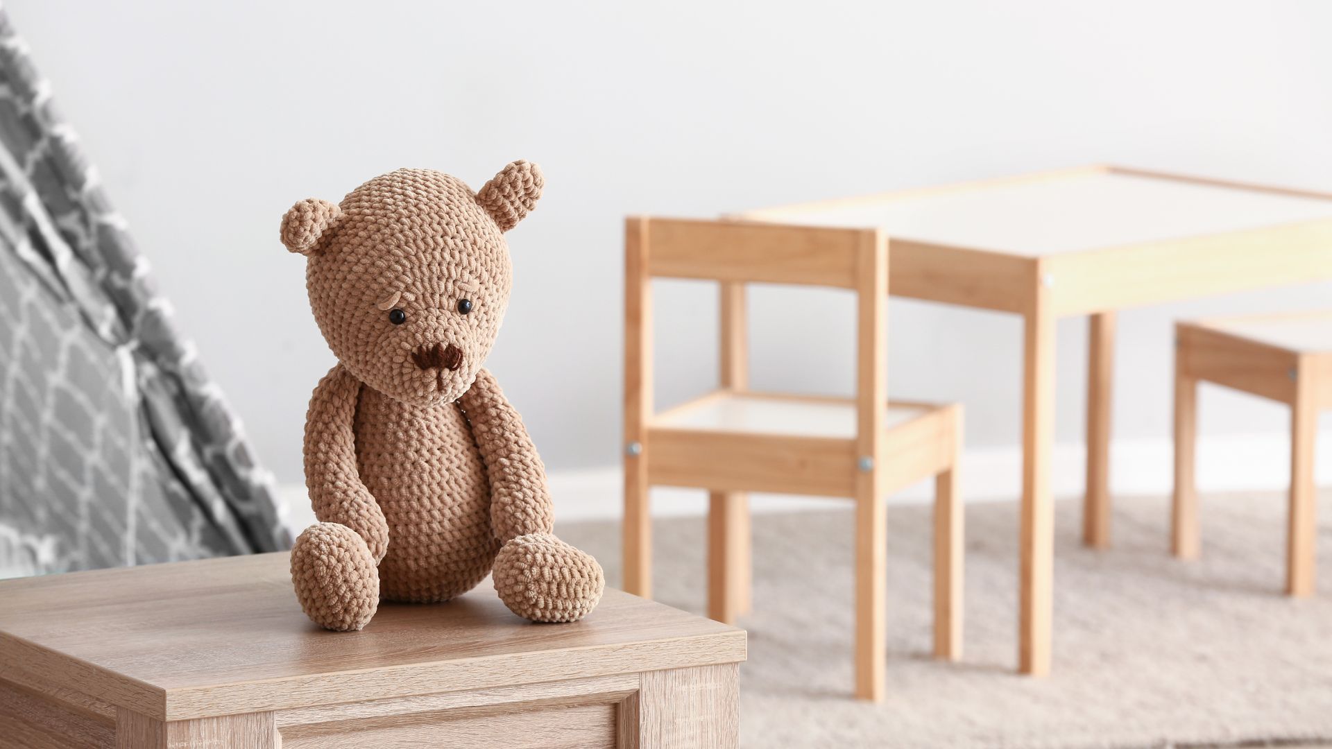 Trauriger Teddybär sitzt auf einem Tisch und möchte über seine Erlebnisse sprechen, weiß aber nicht wie.