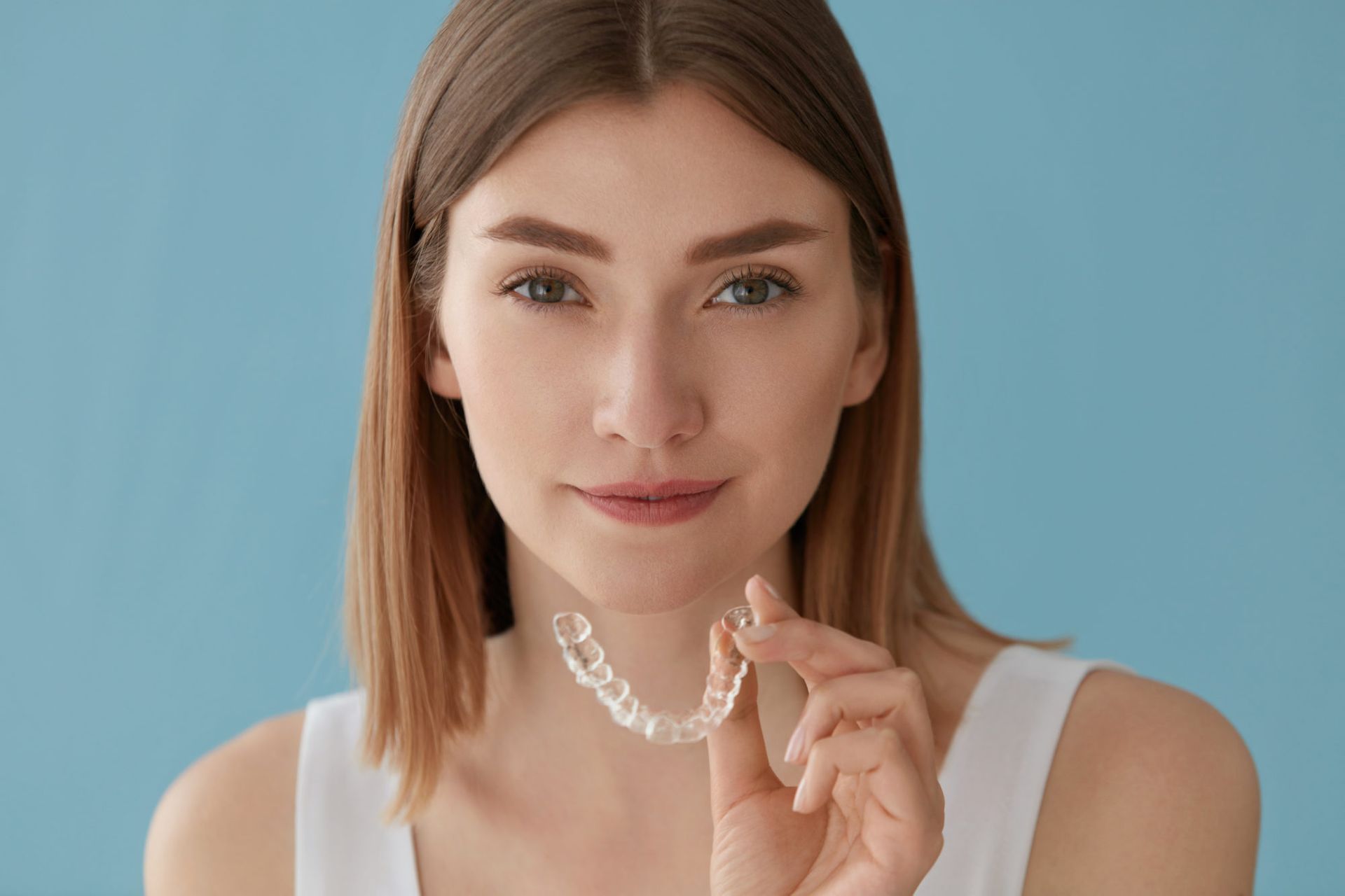 a woman is holding a clear brace in her hand
