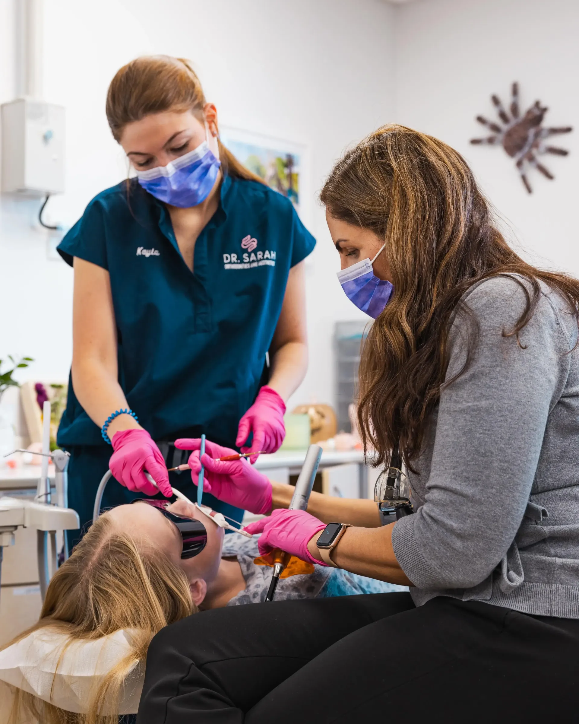 Orthodontist and assistant treating a patient at Dr. Sarah Orthodontics.