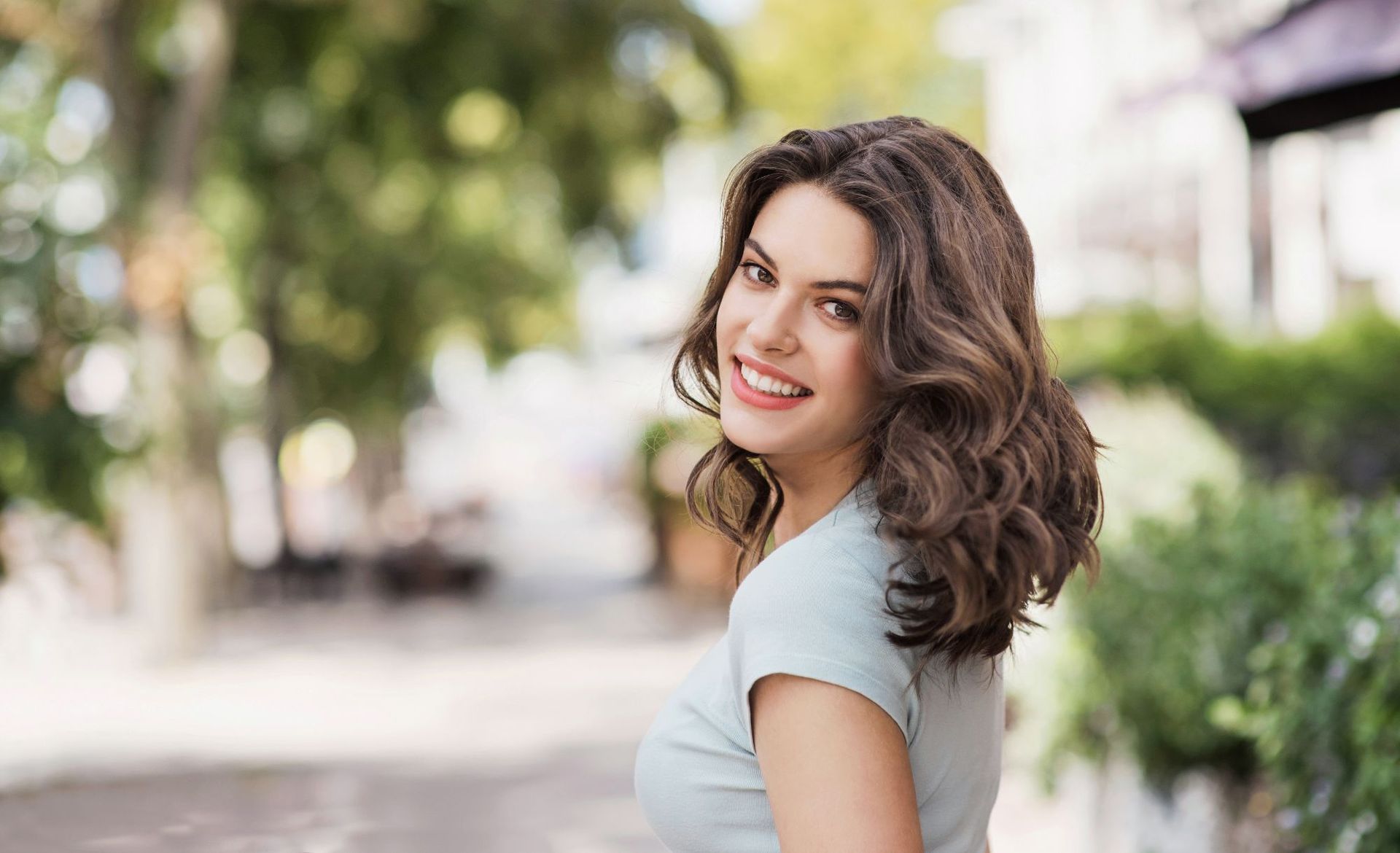 a woman in a white shirt smiles for the camera