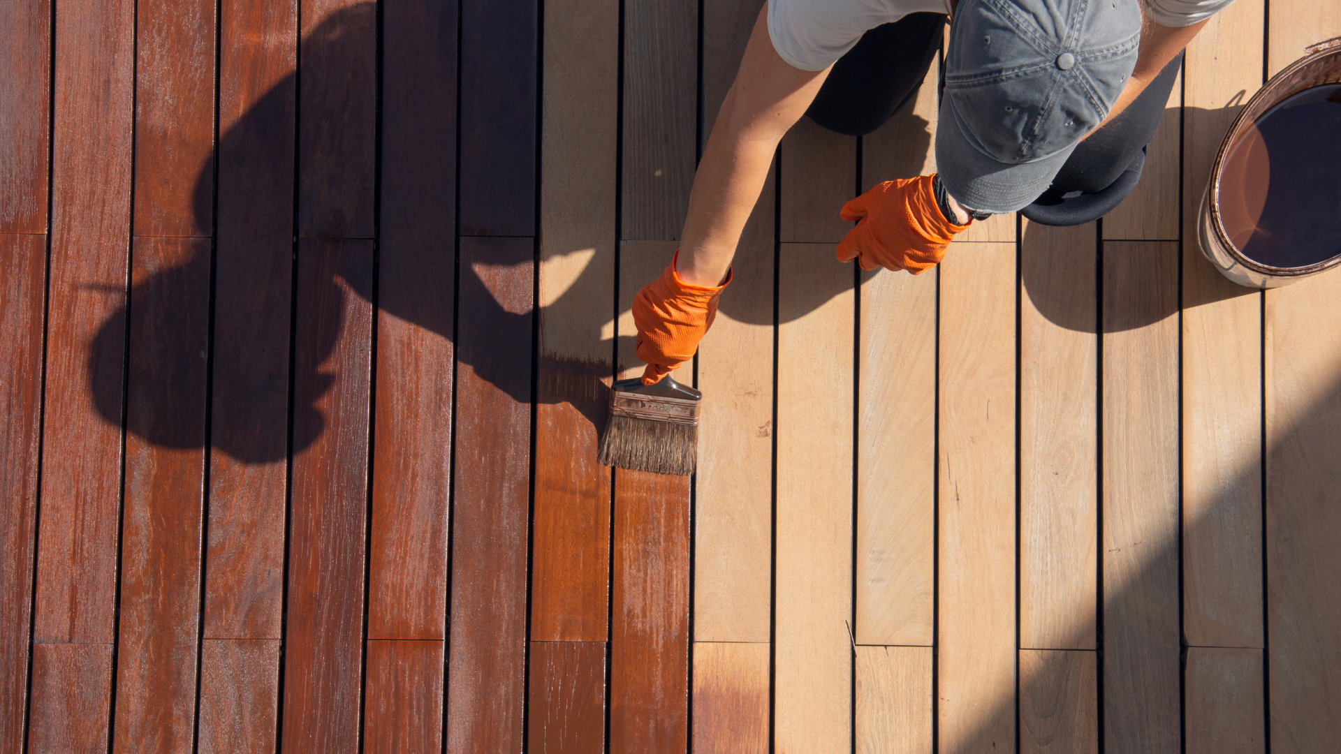 homeowner inspecting peeling deck stain before deck staining services