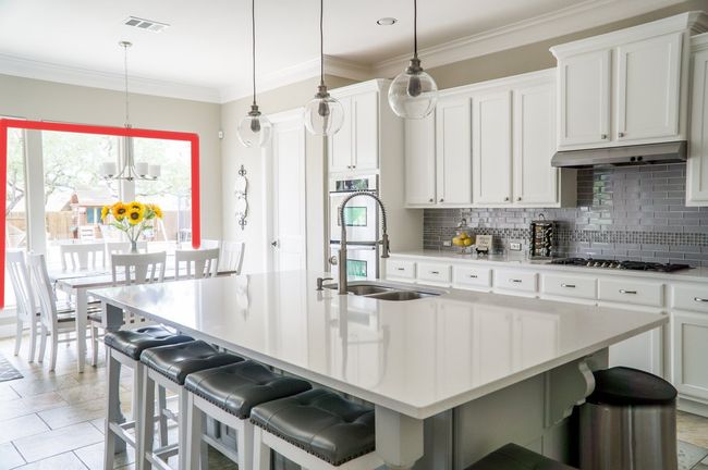 A picture of a kitchen where a wall has been removed allowing access to the backyard