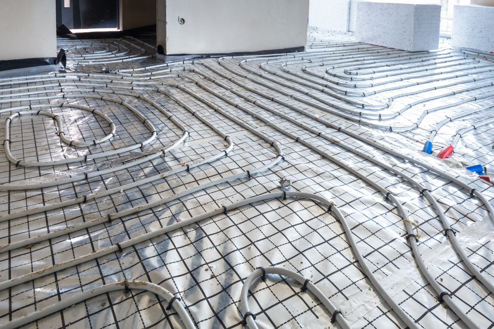 Pipes Laid Out on a Silver Reflective Surface, Part of an in-floor Heating System — Rowal Constructions in New Lambton, NSW
