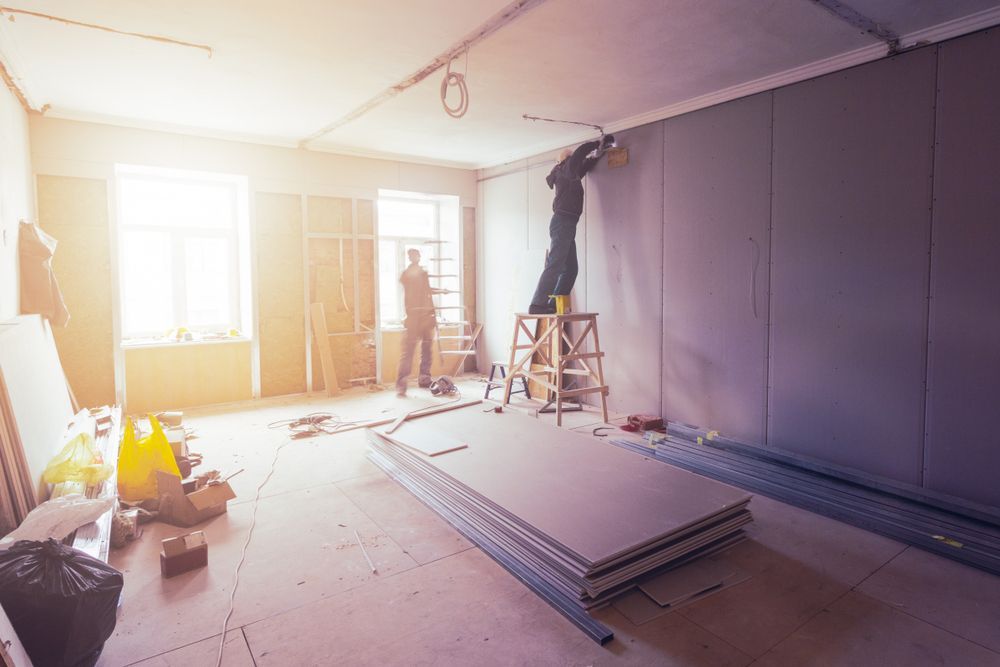 People Installing Drywall in a Room With a Sunny Window — Rowal Constructions in Mayfield, NSW