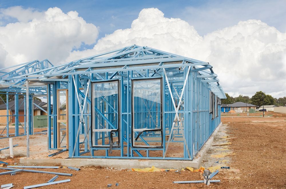 Blue Metal Frame of a House Under Construction on a Dirt Lot — Rowal Constructions in New Lambton, NSW
