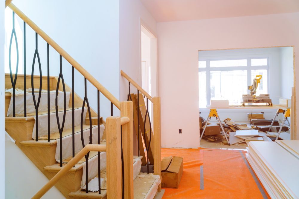 Staircase With Wooden Handrail, Black Spindles, and Building Materials — Rowal Constructions in New Lambton, NSW