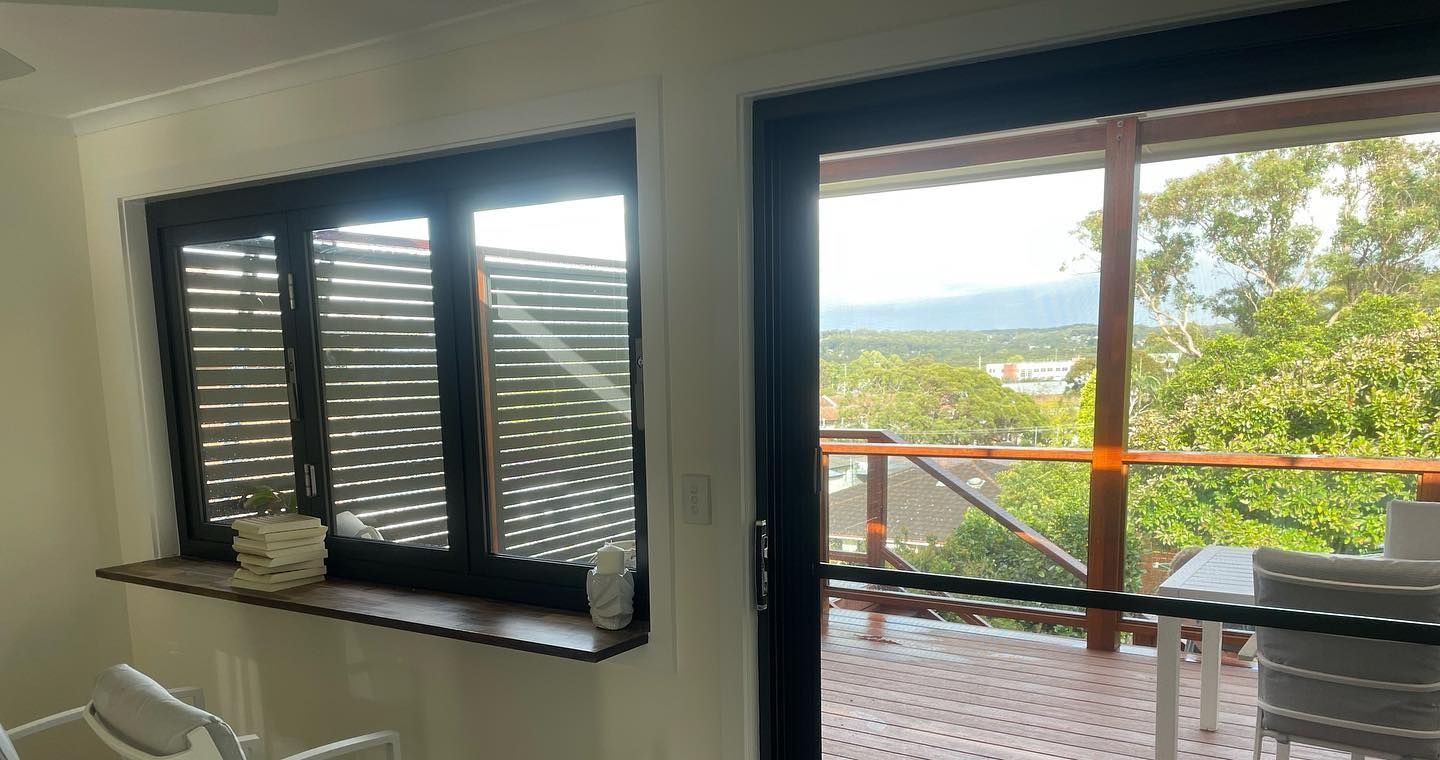 Interior View With Closed, Dark Window Blinds Next to a Sliding Glass Door — Rowal Constructions in New Lambton, NSW