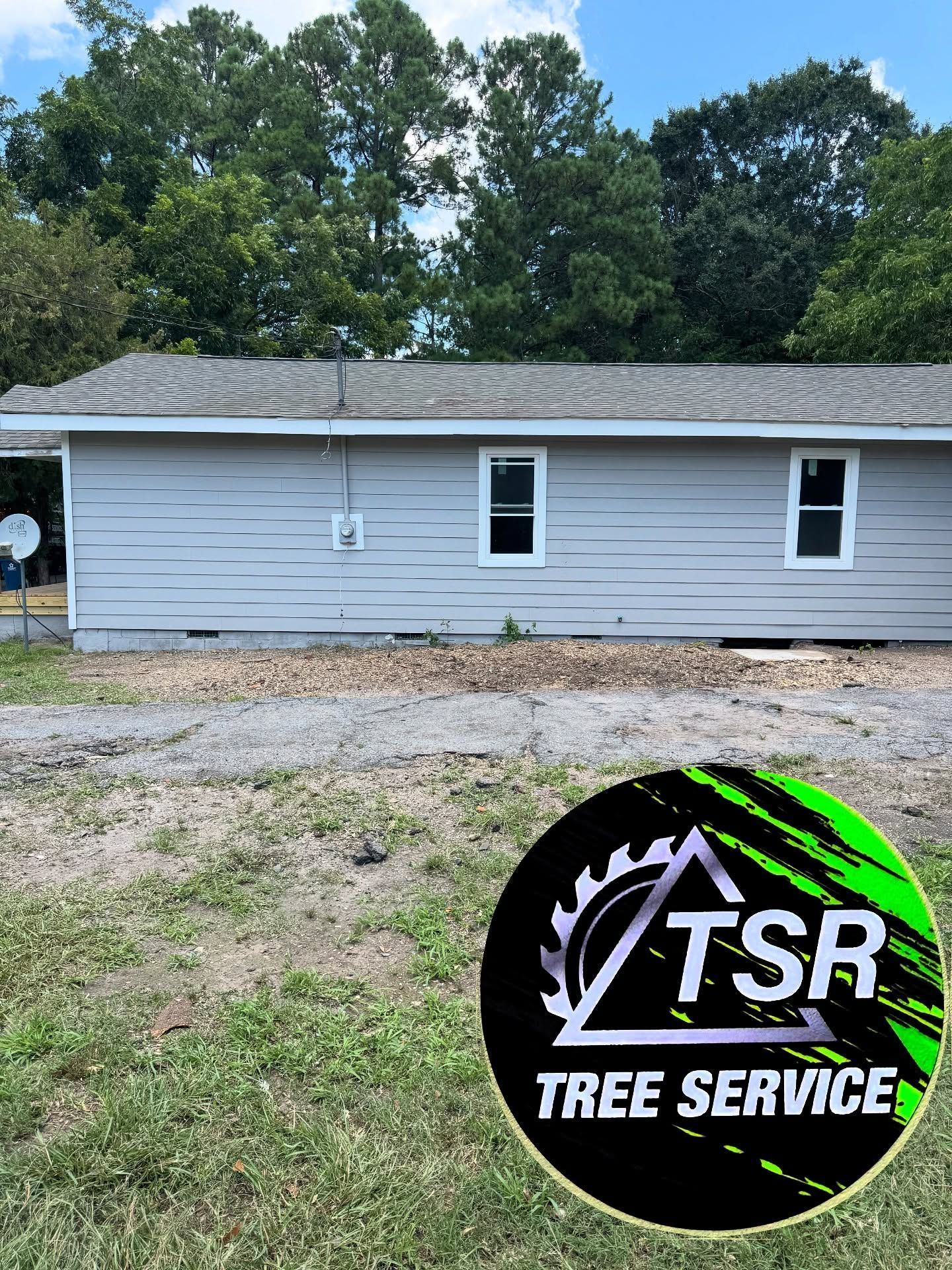 White single-story house with gray siding and a TSR Tree Service logo in the foreground.